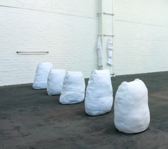 „Module XL 1–5 vor Badezimmerstange“, 2016–2018, Unterwäsche, Füllwatte. Maße: Modul XL 1: 65 x 48 x 40 cm, Modul XL 2: 65 x 44 x 30 cm, Modul XL 3: 62 x 42 x 32 cm, Modul XL 4: 74 x 47 x 31 cm, Modul XL 5: 70 x 46 x 36 cm. Im Hintergrund: „zwei Dreierknüpfmodule“, 2017, Unterhosen, Augen- und Hakenband, Bleiband. Ausstellungsansicht Flottmann-Hallen 2019, linkes Objekt: 114 x 31 x 15 cm, rechtes Objekt: 110 x 25 x 15 cm, © Sylvie Hauptvogel, Foto: Julia Arztmann