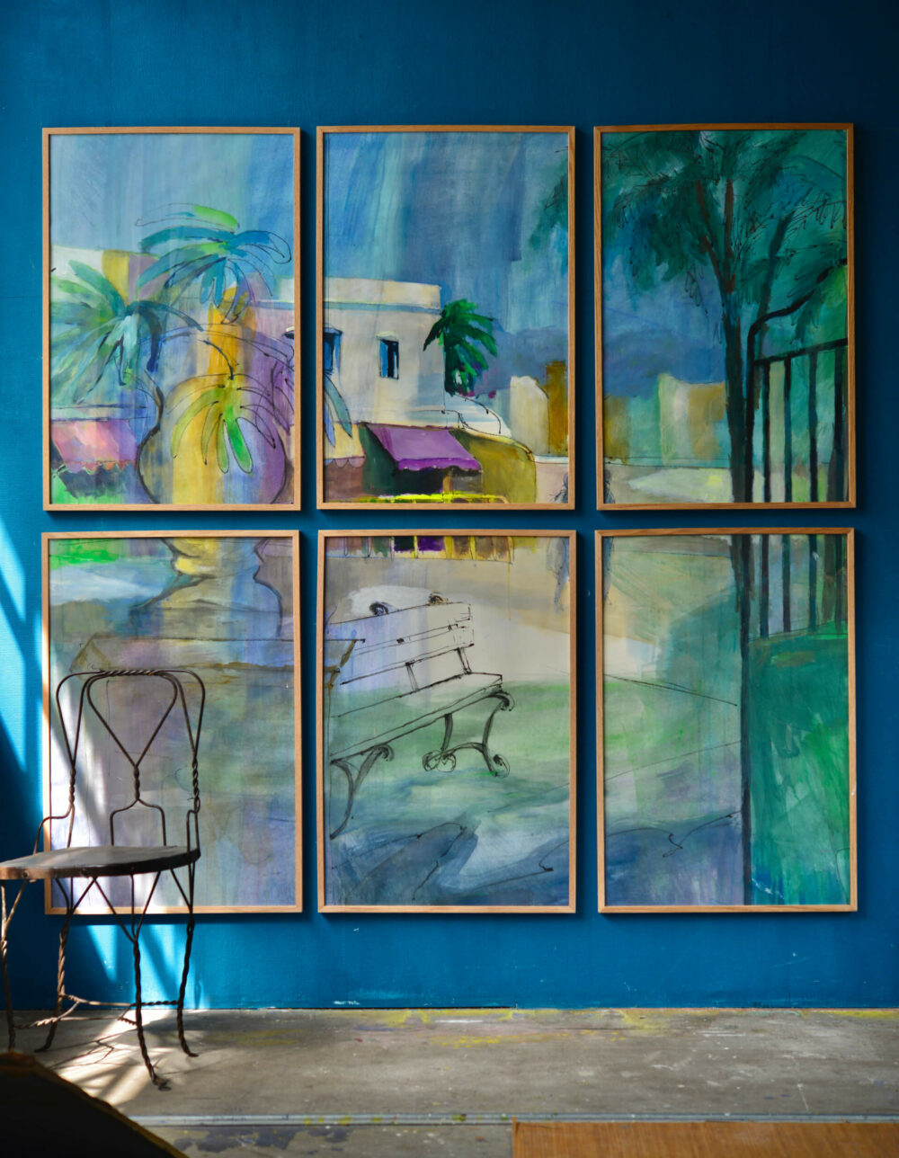 Sechs gerahmte Bilder bilden eine aquarellartige Szene mit Palmen, Gebäuden mit violetten Markisen und einer Parkbank in Blau- und Grüntönen.